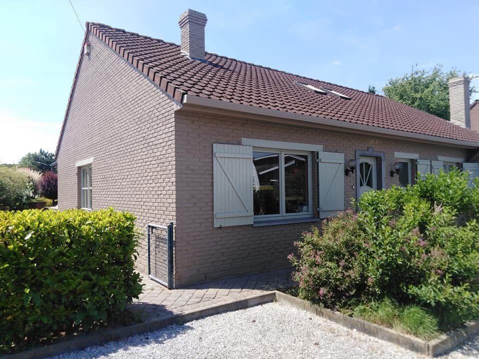 Façade rose avec volets en bois